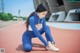 A woman tying up her shoes on a track.