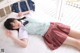 A woman laying on a bed wearing a school uniform.