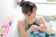 A woman sitting in a bathtub holding a pink ball.