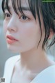 A close up of a woman's face with wet hair.